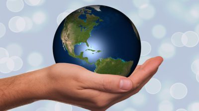 En hand som håller i en jordglob.