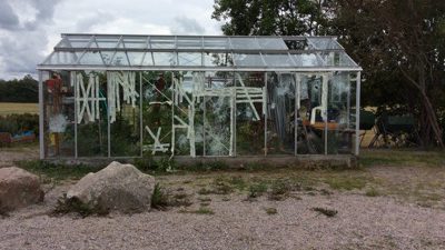 Bild på växthus med krossade rutor.