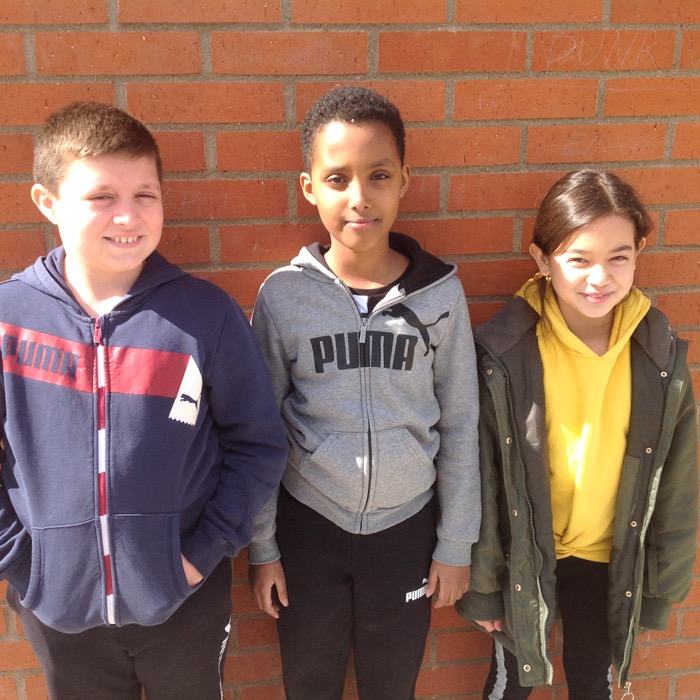 Tre elever mot en tegelvägg