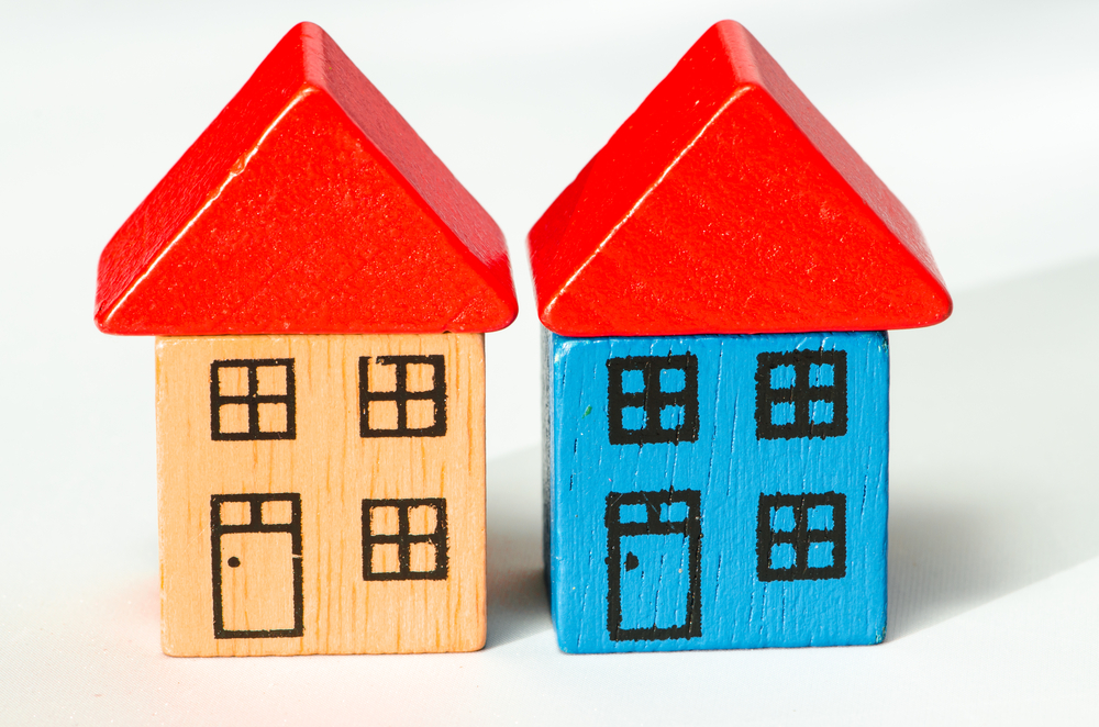 Två hus byggda av leksaksklossar.