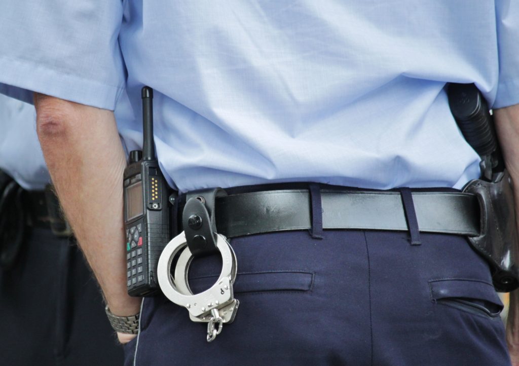 Polis med pistol och handbojor