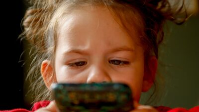 Flicka som tittar på telefonen.
