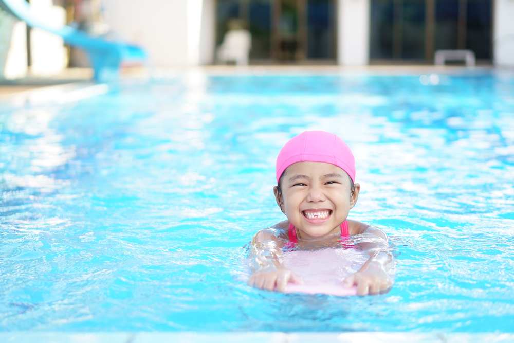 Ett barn som simmar i en pool